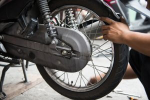 man performing a change of a motorcycle tire